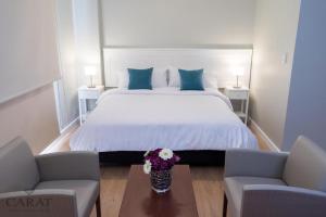 een slaapkamer met een groot wit bed met blauwe kussens bij Carat Apart Boutique in Rosario
