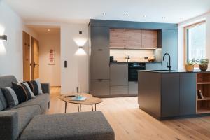 a living room with a couch and a kitchen at Salzkammergut Lodge in Ebensee