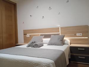 um quarto com uma cama grande com duas toalhas em Apartamento Mirabel em Rosal