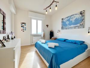 1 dormitorio con 1 cama azul en una habitación blanca en Seaside Luxury Apartment by Holiday World, en Cogoleto