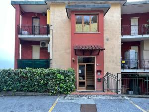 un edificio rojo con una puerta en un estacionamiento en Seaside Luxury Apartment by Holiday World, en Cogoleto