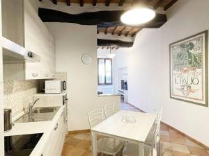 een keuken met een tafel en een witte tafel en stoelen bij Casa Montanini Centro Storico in Siena