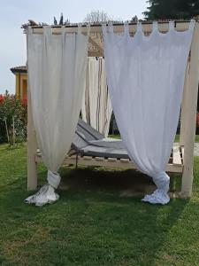 Cama blanca con dosel y colchón en la hierba en Villa Dacia, en Guiglia