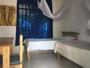 a room with two beds and a window at Eazy's Place in Dar es Salaam
