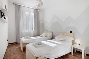 a bedroom with two beds and a window at Casa Glicine in Domaso