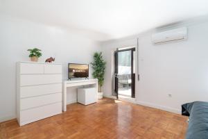 um quarto branco com uma cómoda e uma secretária em Calm Sunny House with Terrace no Porto