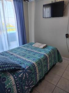 1 dormitorio con 1 cama, TV y ventana en Homestay Iquique, en Iquique