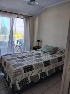 1 dormitorio con cama y ventana grande en Homestay Iquique, en Iquique