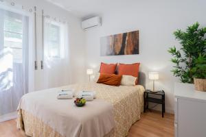 um quarto branco com uma cama com almofadas laranja em Calm Sunny House with Terrace no Porto