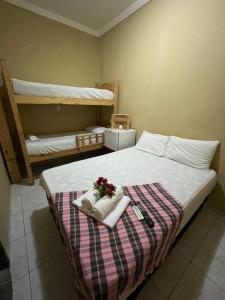 Un dormitorio con una cama con toallas y flores. en Pousada Lampião e Maria Bonita, en Natal