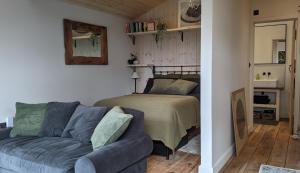 a living room with a couch and a bed at A Somerset Countryside Lodge in Holcombe