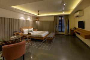 a hotel room with a bed and a table at Indus Suites in Nagpur