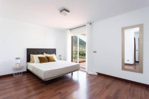 a white bedroom with a bed and a mirror at Villa esclusiva a 1 chilometro da Playa de Los Cristianos in Los Cristianos