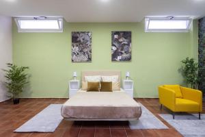 a bedroom with a bed and a yellow chair at Villa esclusiva a 1 chilometro da Playa de Los Cristianos in Los Cristianos