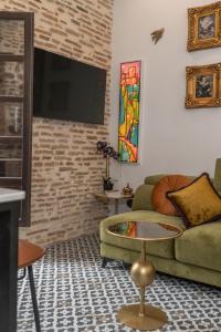 a living room with a green couch and a tv at tuGuest Puerta del Dauro Apartment in Granada +35 photos