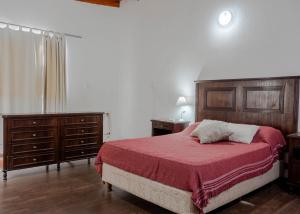 um quarto com uma cama com um cobertor vermelho e mobiliário em madeira em Complejo Yaguareté em Corrientes