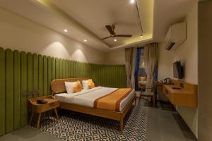 a hotel room with a bed and a desk at Indus Suites in Nagpur