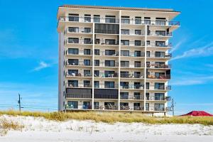 a tall building on the beach next to the sand at Sundunes 122 in Navarre