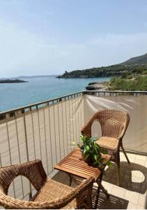 two chairs and a table on a balcony with the ocean at B&B Fronte Mare in Marina di Camerota