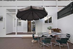 a patio with a table and an umbrella at Casa da Letinhas in Albufeira