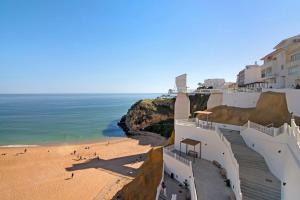 una vista di una spiaggia con edifici e l'oceano di Casa da Letinhas ad Albufeira