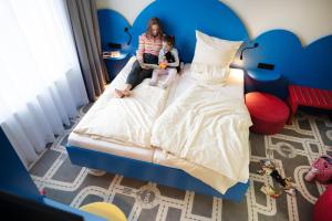 a little girl and a child sitting on a bed at LIHO - einfach Lübeck in Lübeck