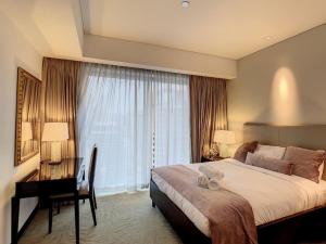 a bedroom with a bed and a desk and a window at Key View - Emaar Residences, Marina Mall in Dubai