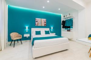 a blue bedroom with a bed and a chair at I Mori dell’Etna in Giardini Naxos