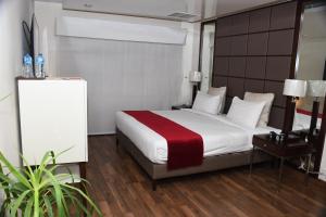 ein Schlafzimmer mit einem großen Bett mit einer roten Decke in der Unterkunft Rockville House managed & operated by Serai Boutique Hotels and Resorts in Islamabad