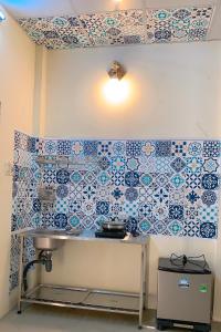 cocina con azulejos azules y blancos en la pared en Biyu’s Cozy House 2, en Hanói