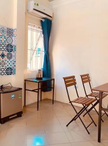 uma sala de jantar com uma mesa e duas cadeiras em Biyu’s Cozy House 2 em Hanói