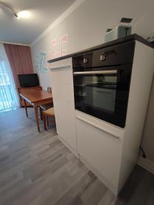 a kitchen with a black and white oven and a table at HarzLiebe in Herzberg am Harz