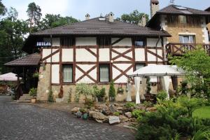 a house with a garden in front of it at AQUARIUS Eco Family Hotel in Lviv