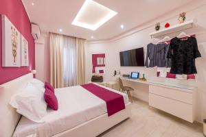 a bedroom with a bed and a desk in a room at I Mori dell’Etna in Giardini Naxos