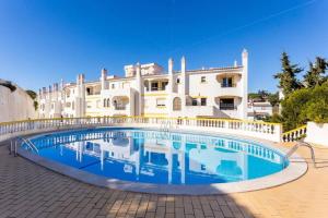 a large house with a swimming pool in front of it at Sunny Duplex W/ Pool & Balcony by LovelyStay in Carvoeiro