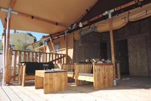 a patio with a table and chairs on a deck at Silver Coast Glamping luxury lodge in Alcobaça