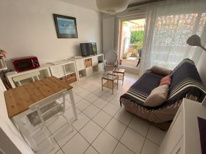 ein Wohnzimmer mit einem Sofa und einem Tisch in der Unterkunft Appartement Arcachon, 2 pièces, 3 personnes - FR-1-474-167 in Arcachon