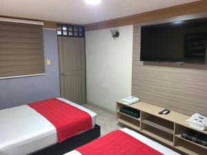 um quarto com 2 camas e uma televisão de ecrã plano em Hotel Don Juan em Guadalajara de Buga