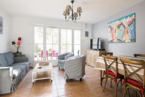 una sala de estar con un sofá y una mesa en Maison Telline, en Saint-Martin-de-Ré