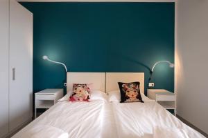 a bedroom with a white bed with two pillows on it at Tennis / Pool / Barbecue in Bardolino