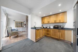 a kitchen with wooden cabinets and a chair in a room at Charming Cottage in Hampstead Heath in London