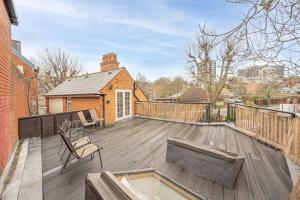 a large deck with chairs and a house at Charming Cottage in Hampstead Heath in London