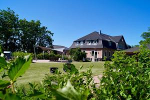 ein großes Haus mit einem Hof davor in der Unterkunft Ferienwohnung Nord in Fehmarn