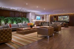 a hotel lobby with couches and chairs and a television at PortoBay Rio de Janeiro in Rio de Janeiro