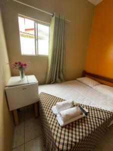 a small bedroom with a bed and a window at Pousada Lampião e Maria Bonita in Natal