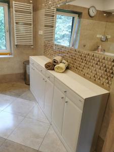 a bathroom with white cabinets and a large mirror at Siedlisko Bliss Garden Retreat House ZielonoMi in Lengenquell +77 photos