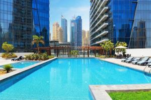 a swimming pool with a city skyline in the background at Key View - Silverene Tower in Dubai