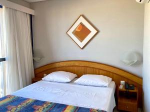 a bed with two white pillows in a bedroom at Hotel Flat Classic in Fortaleza