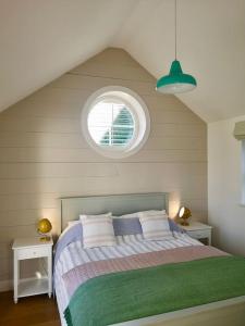 um quarto com uma cama grande e uma janela em The little post house. A perfect village retreat, with stunning views. em Boscastle