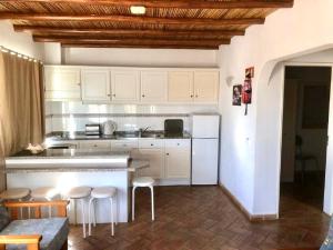 a kitchen with white cabinets and bar stools at SOLAR DOS AVÓS in Guia